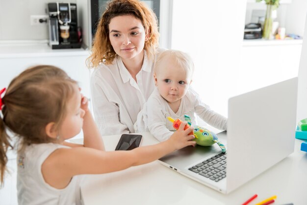 Mittlere Schussmutter, die mit Baby arbeitet