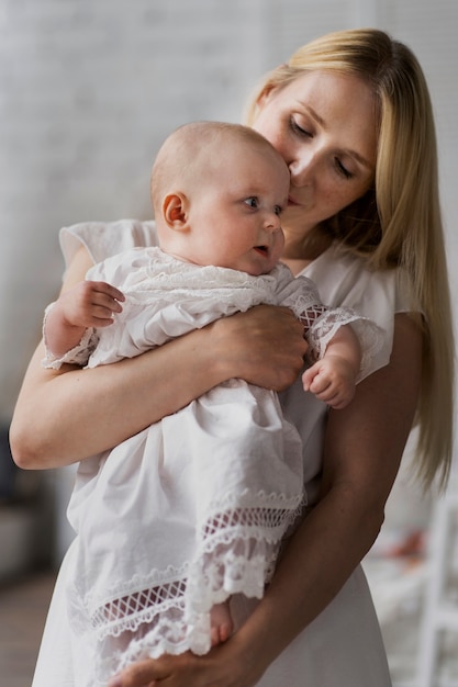 Mittlere Schussmutter, die nettes Baby hält