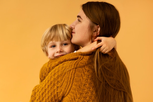 Kostenloses Foto mittlere schussmutter, die smiley-kind hält