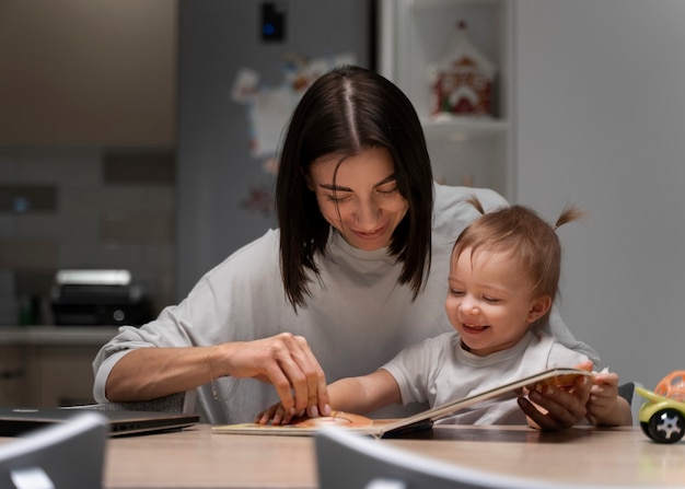 Mittlere Schussmutter und -baby mit Buch