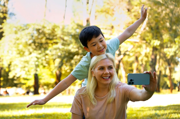 Mittlere Schussmutter und -junge, die selfie nehmen