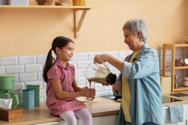 Kostenloses Foto mittlere schussoma und -mädchen, die zusammen kochen