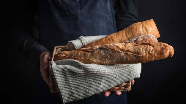 Kostenloses Foto mittlere schussperson, die brot hält