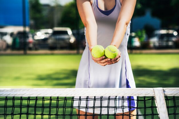 Mittlerer Abschnitt der Sportlerin Tennisbälle halten