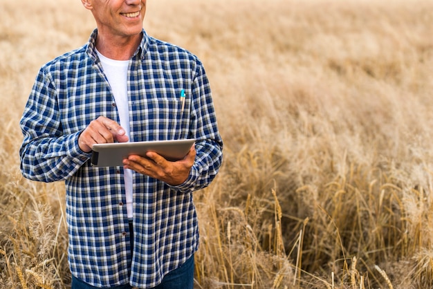 Mittlerer Ansichtlandwirt mit einer Tablette