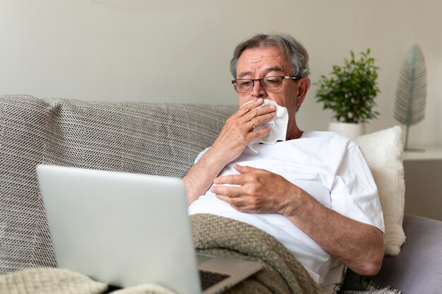 Mittlerer erschossener alter kranker Mann auf der Couch