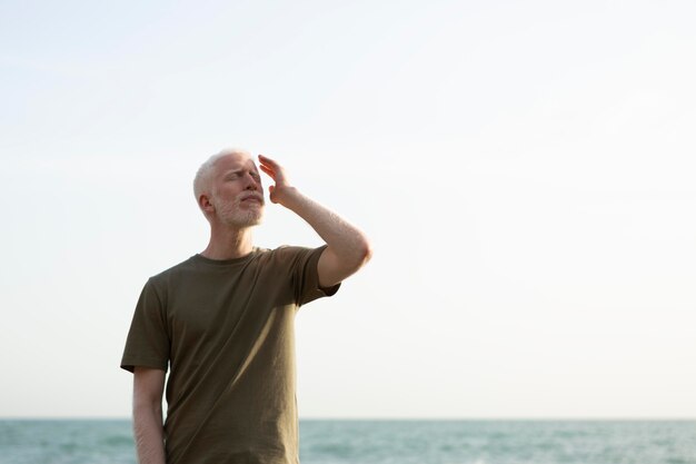 Mittlerer Schuss älterer Mann, der am Meer aufwirft