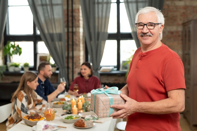 Kostenloses Foto mittlerer schuss älterer mann mit geschenk