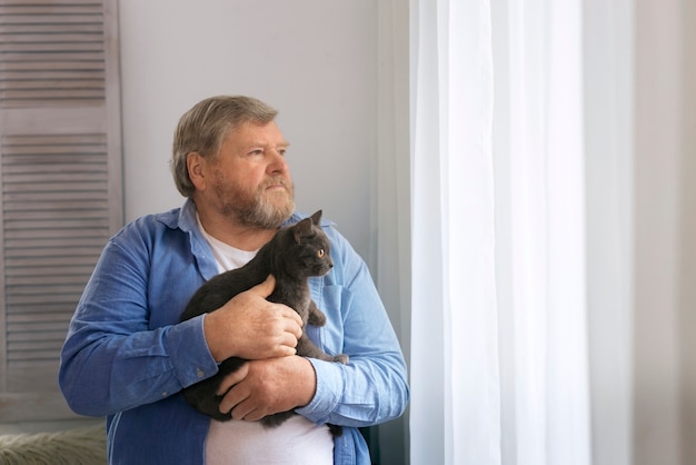 Kostenloses Foto mittlerer schuss älterer mann mit katze