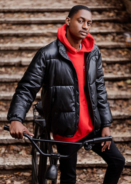 Mittlerer Schuss afroamerikanischer Mann und sein Fahrrad