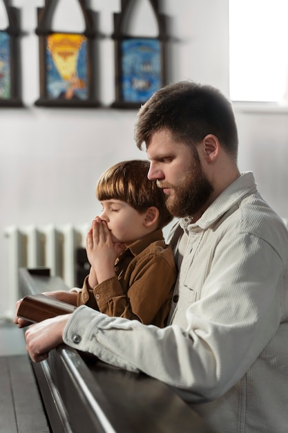 Mittlerer Schuss christlicher Vater und Junge in der Kirche