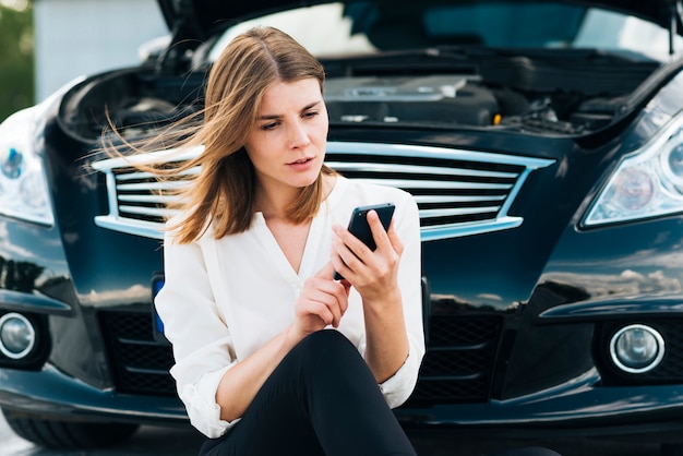 Kostenloses Foto mittlerer schuss der frau telefon überprüfend