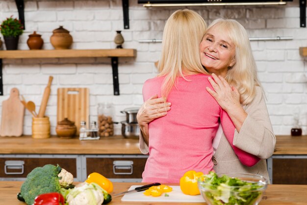 Mittlerer Schuss der Mutter ihre Tochter umarmend