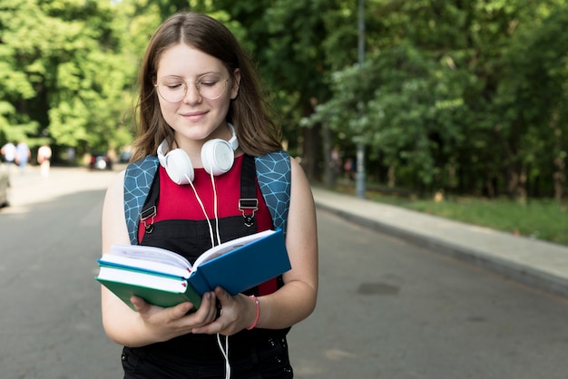 Mittlerer Schuss des Highschool Mädchens ein Buch lesend