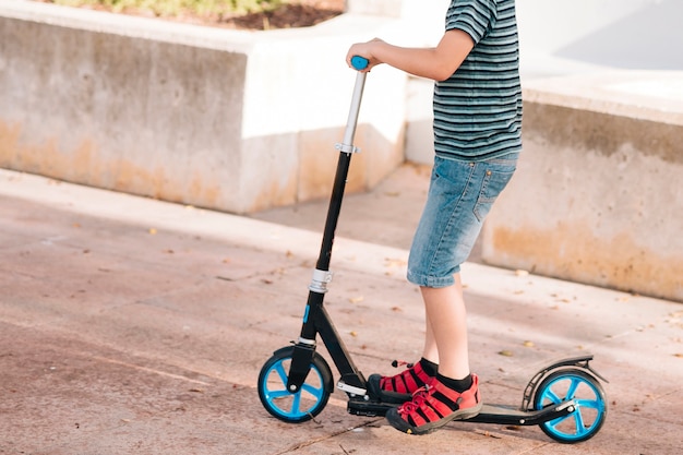 Kostenloses Foto mittlerer schuss des jungen auf roller