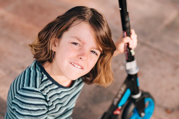 Mittlerer Schuss des Jungen mit Roller