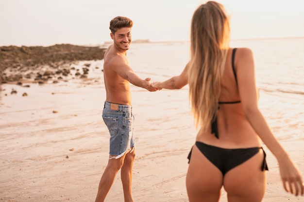 Mittlerer Schuss des Koppelhändchenhaltens am Strand