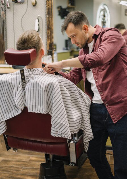 Mittlerer Schuss des Mannes am Friseursalon