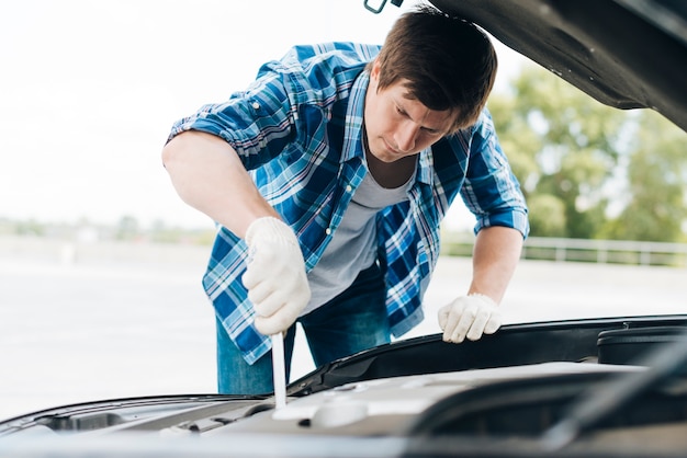 Mittlerer Schuss des Mannes arbeitend an Auto