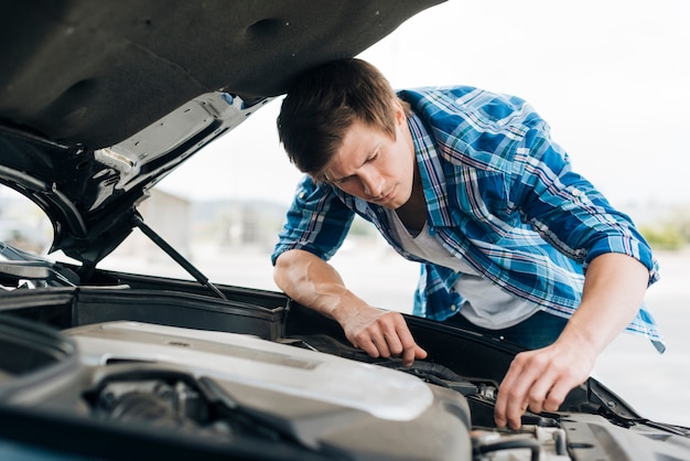 Mittlerer Schuss des Mannes Motor überprüfend