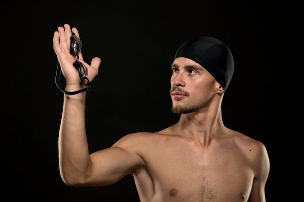 Mittlerer Schuss des Schwimmers, der Schutzbrille in der Hand hält