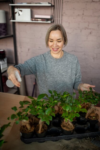 Mittlerer Schuss Florist, der Blumen gießt