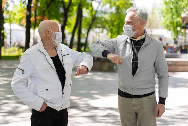 Mittlerer Schuss Freunde Ellbogen stoßen