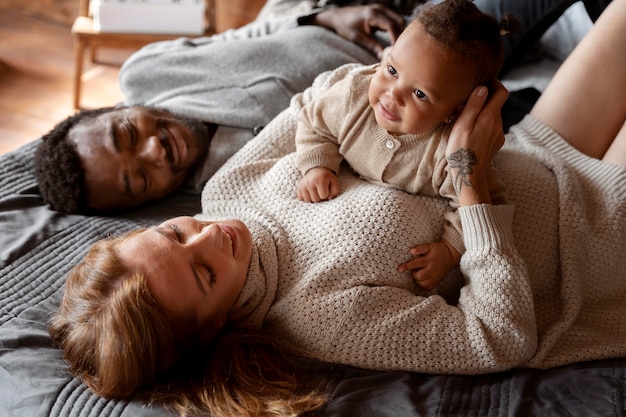 Mittlerer Schuss glückliche Familie, die mit Kind legt