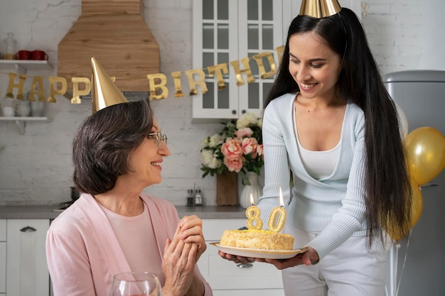 Kostenloses Foto mittlerer schuss glückliche frauen mit kuchen