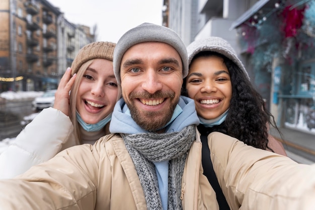 Kostenloses Foto mittlerer schuss glückliche freunde, die selfie nehmen