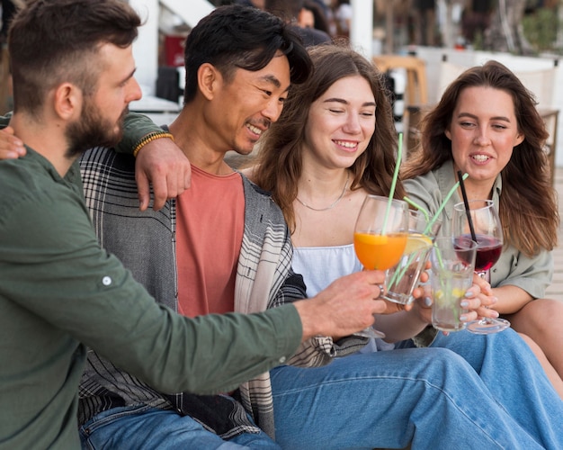 Mittlerer Schuss glückliche Freunde mit Getränken