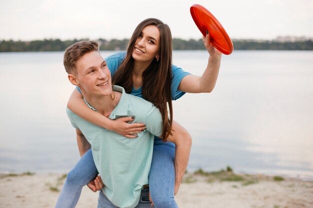 Mittlerer Schuss glückliche Freunde mit rotem Frisbee