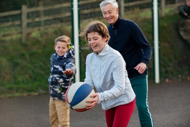 Mittlerer Schuss glückliche Leute mit Ball