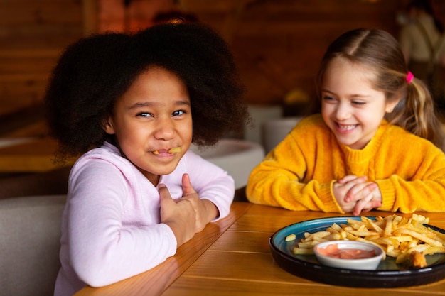 Kostenloses Foto mittlerer schuss glückliche mädchen mit essen