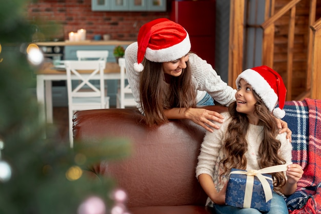 Kostenloses Foto mittlerer schuss glückliche tochter und mutter mit geschenk