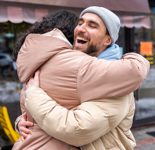 Kostenloses Foto mittlerer schuss glücklicher mann, der frau umarmt