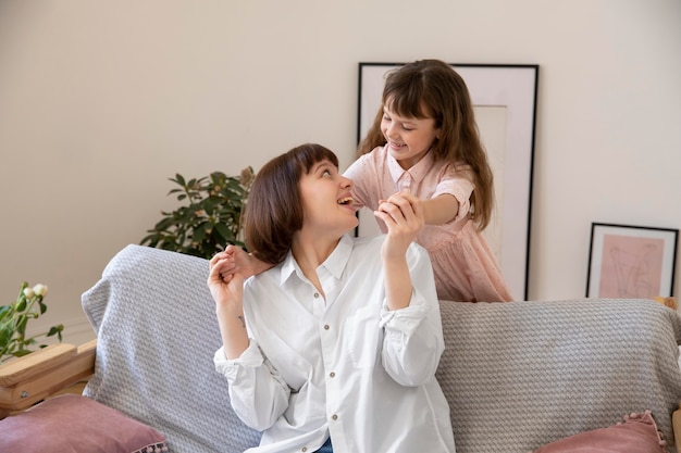 Mittlerer Schuss glückliches Mädchen und Mutter