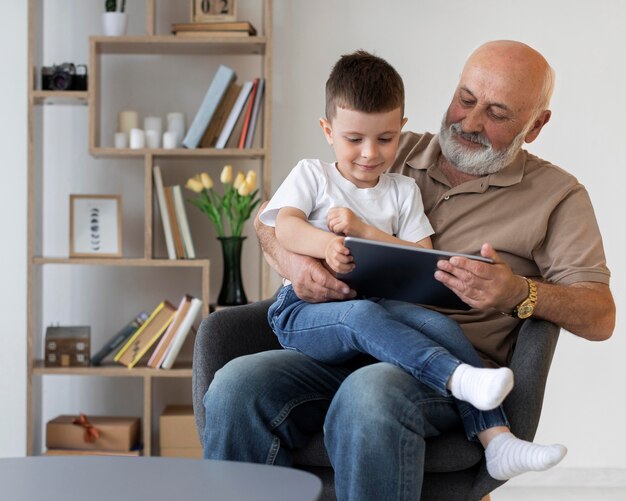 Mittlerer Schuss Großvater mit Kind und Tablette