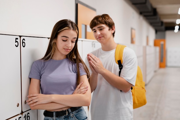 Mittlerer Schuss Junge, der sich bei Mädchen entschuldigt