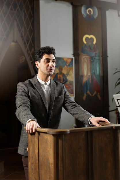 Kostenloses Foto mittlerer schuss junger pastor, der in der kirche predigt