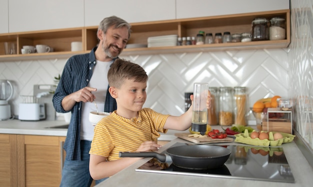 Mittlerer Schuss Kind und Vater kochen