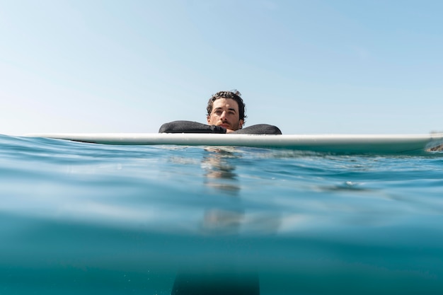 Kostenloses Foto mittlerer schuss mann auf surfbrett