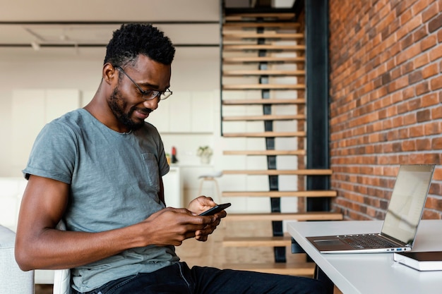 Mittlerer Schuss Mann, der am Telefon tippt