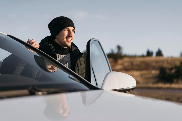 Mittlerer Schuss Mann, der aus dem Auto steigt