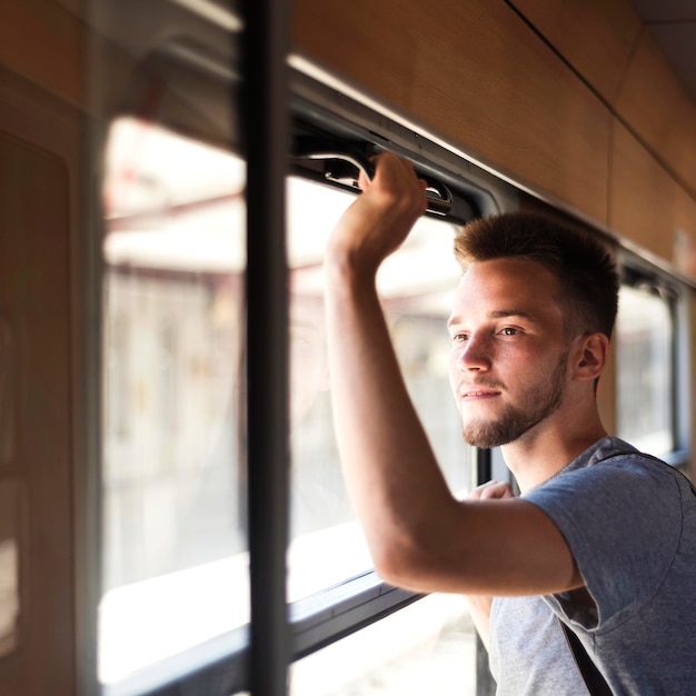 Kostenloses Foto mittlerer schuss mann, der aus dem fenster schaut