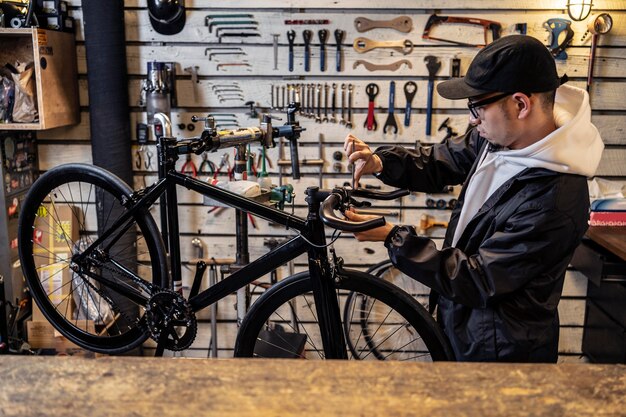 Mittlerer Schuss Mann, der Fahrrad repariert