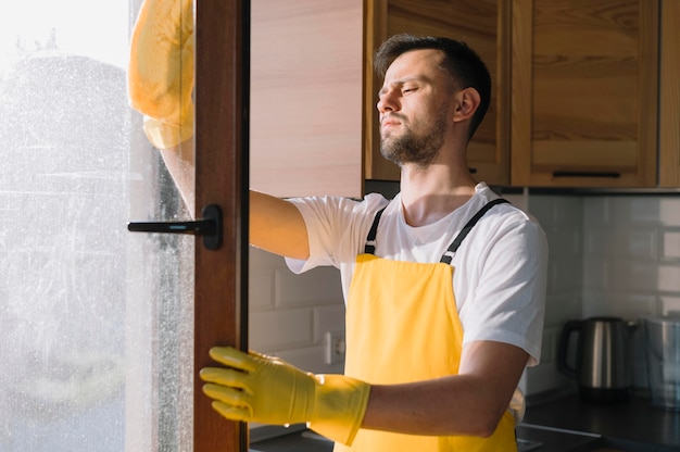 Mittlerer Schuss Mann, der Fenster reinigt