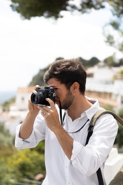 Mittlerer Schuss Mann, der Fotos mit Kamera macht