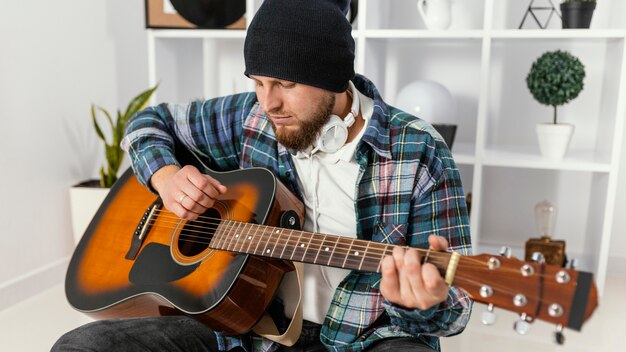 Mittlerer Schuss Mann, der Gitarre hält