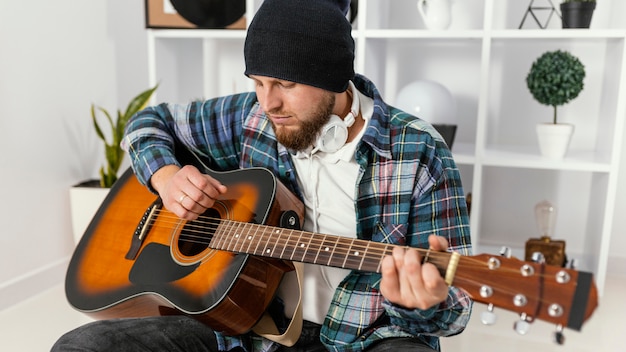 Mittlerer Schuss Mann, der Gitarre hält